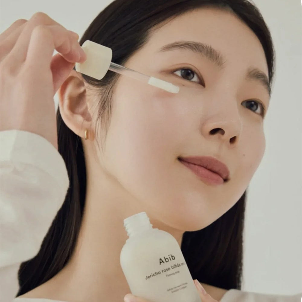 Model applying Abib Jericho Rose Bifida Serum Firming Drop to face